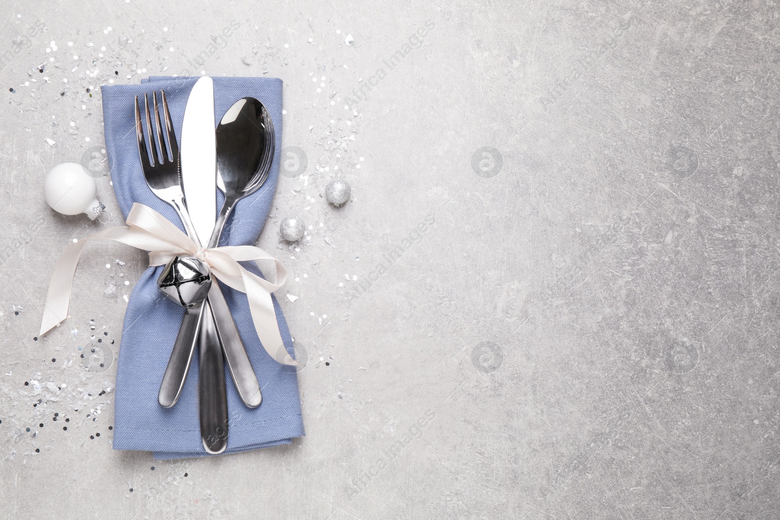 Photo of Cutlery set on grey table, top view with space for text. Christmas celebration