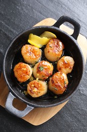 Photo of Delicious fried scallops on dark gray textured table, top view
