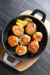 Delicious fried scallops on dark gray textured table, top view