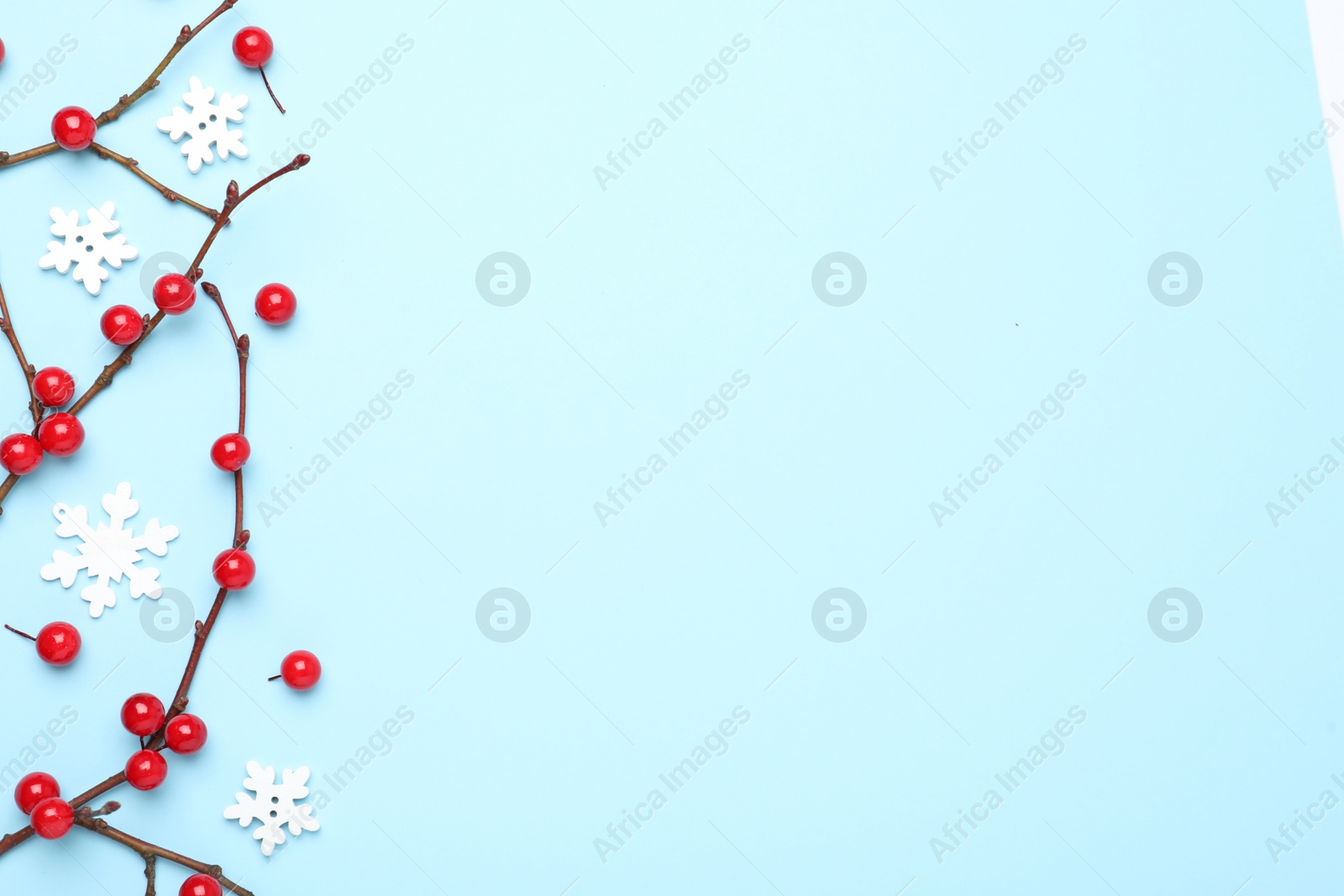 Photo of Winter composition with decorative branches on light blue background, flat lay. Space for text