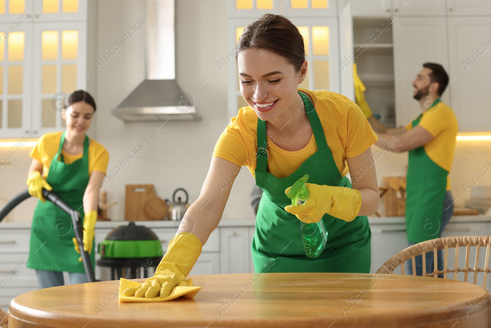 Photo of Team of professional janitors working in kitchen