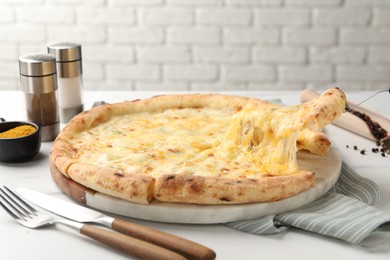 Photo of Taking piece of delicious cheese pizza at white table