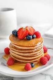 Photo of Tasty pancakes with berries and honey on plate