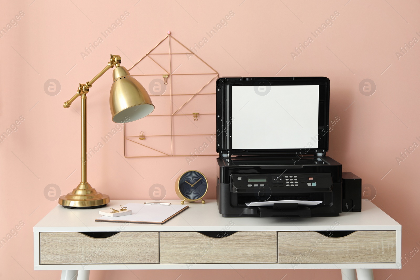 Photo of New modern printer with paper on white table at workplace