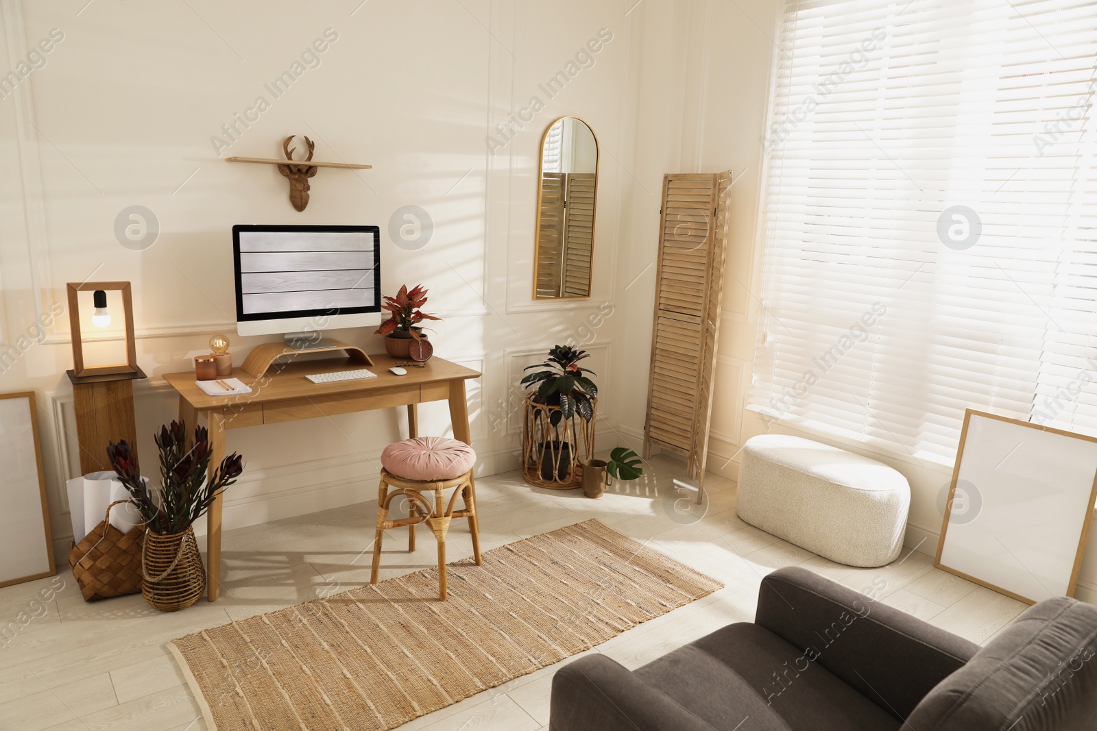 Photo of Comfortable workplace with modern computer and beautiful plants in room. Interior design