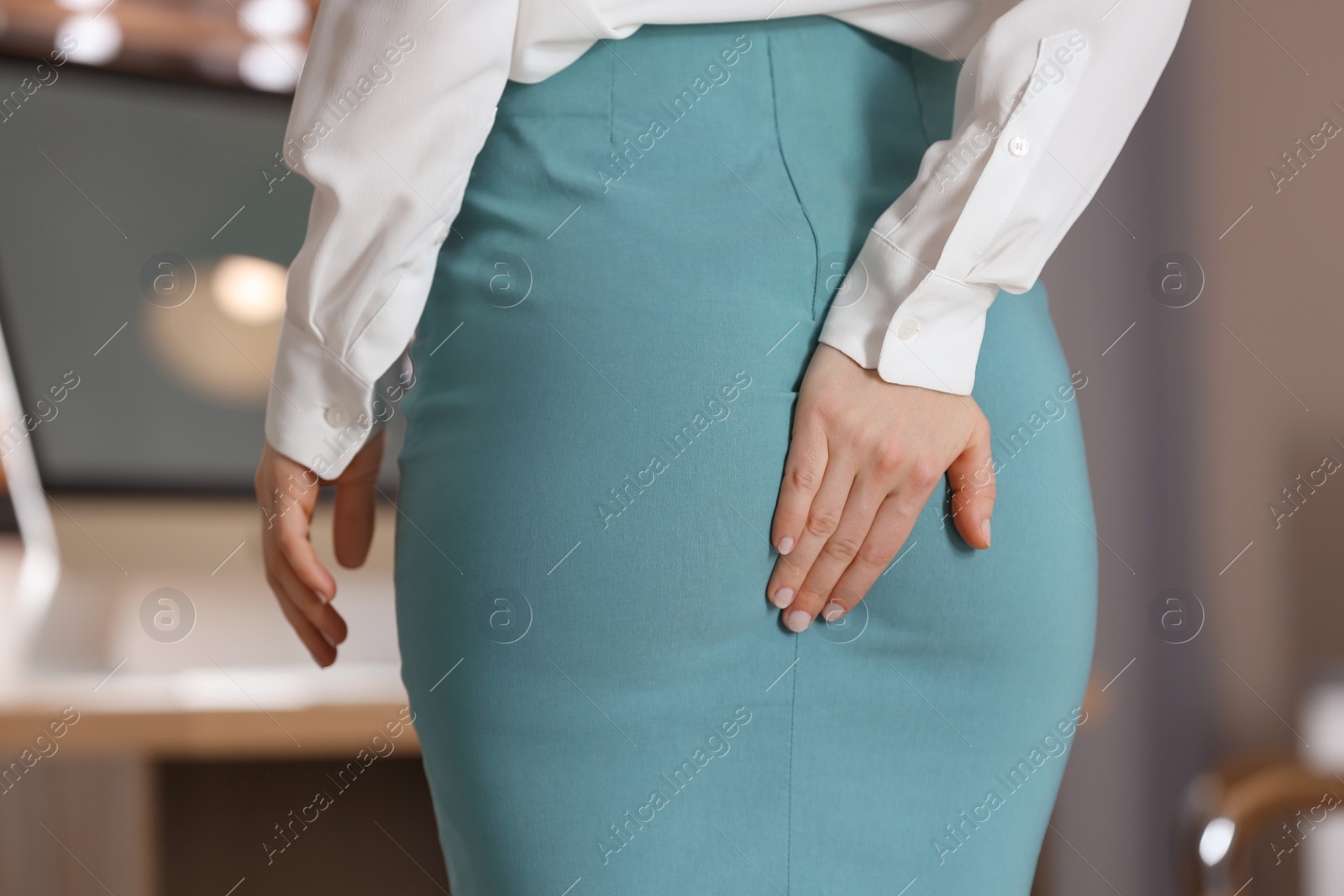 Photo of Young woman suffering from hemorrhoid in office, closeup