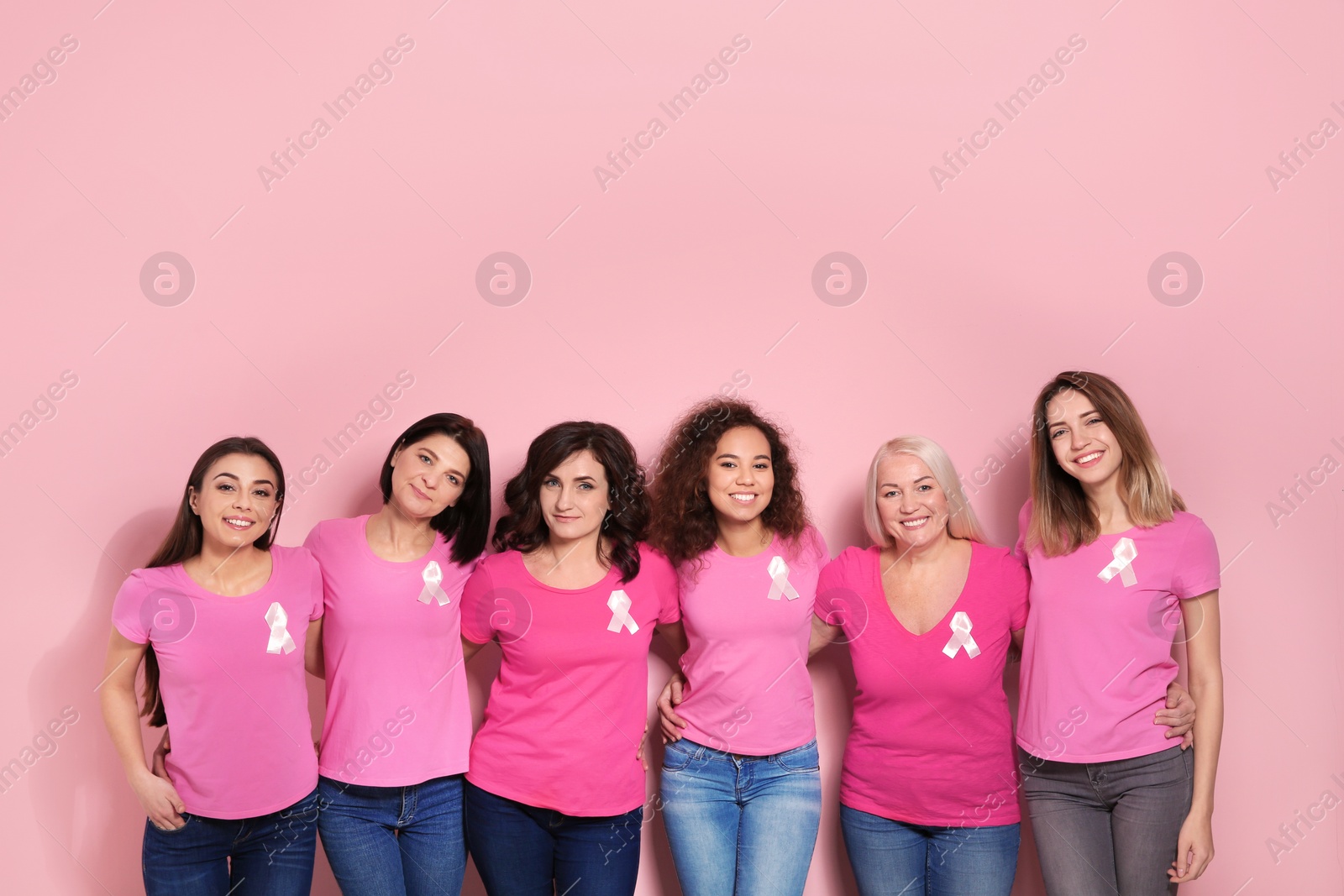 Photo of Group of women with silk ribbons on color background. Breast cancer awareness concept