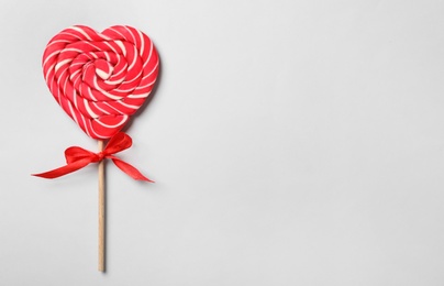 Sweet heart shaped lollipop on light grey background, top view with space for text. Valentine's day celebration