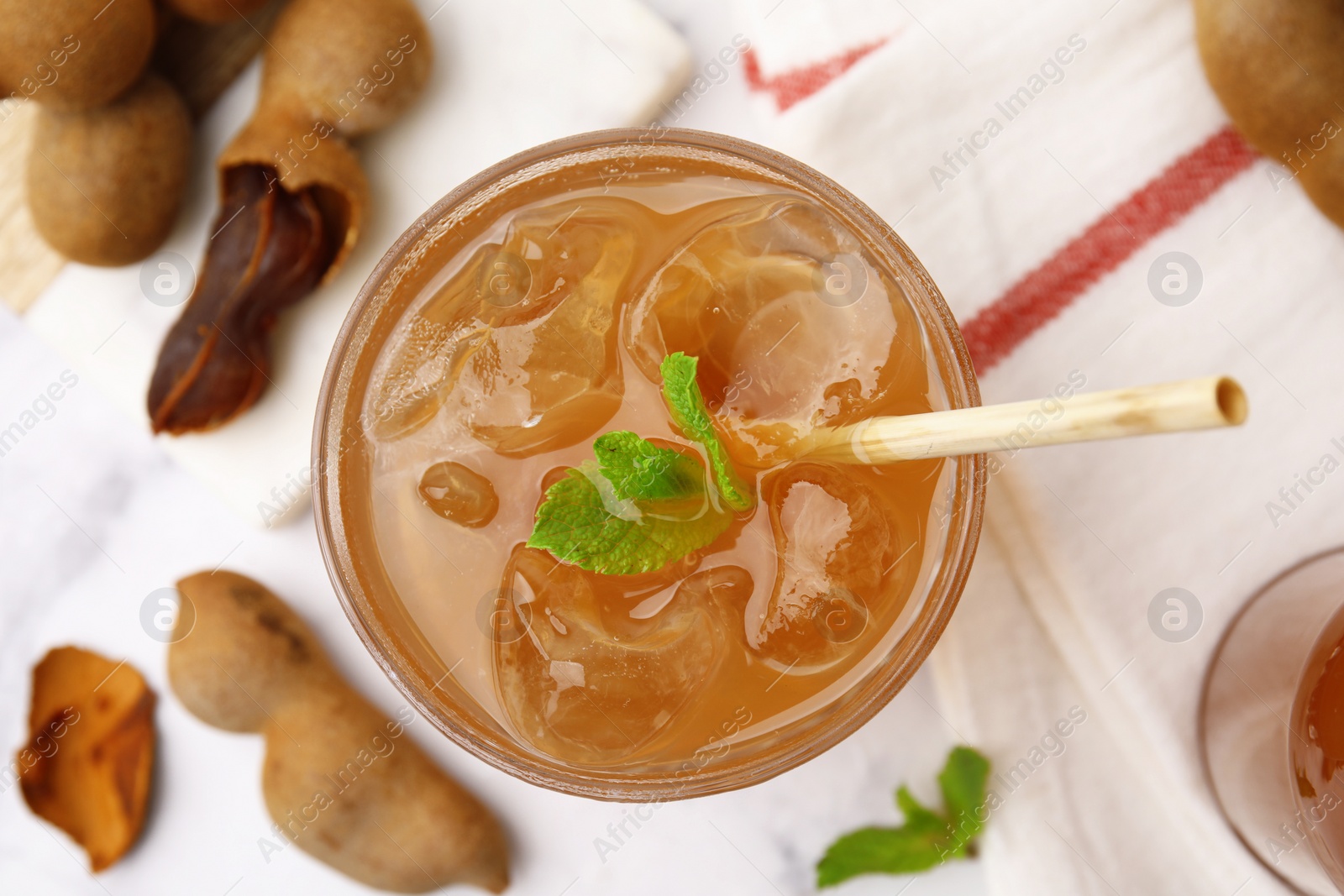 Photo of Freshly made tamarind juice with mint on white table, top view