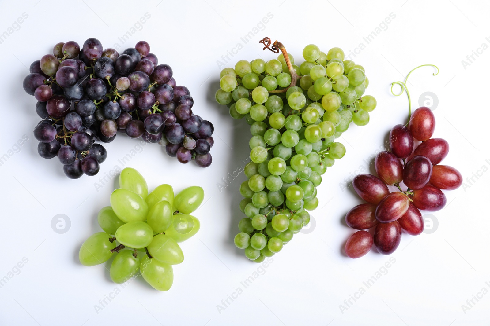 Photo of Different fresh ripe juicy grapes on white background, top view