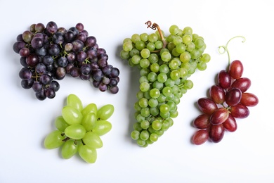 Different fresh ripe juicy grapes on white background, top view