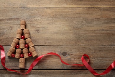 Christmas tree made of wine corks and holiday decoration on wooden table, flat lay. Space for text