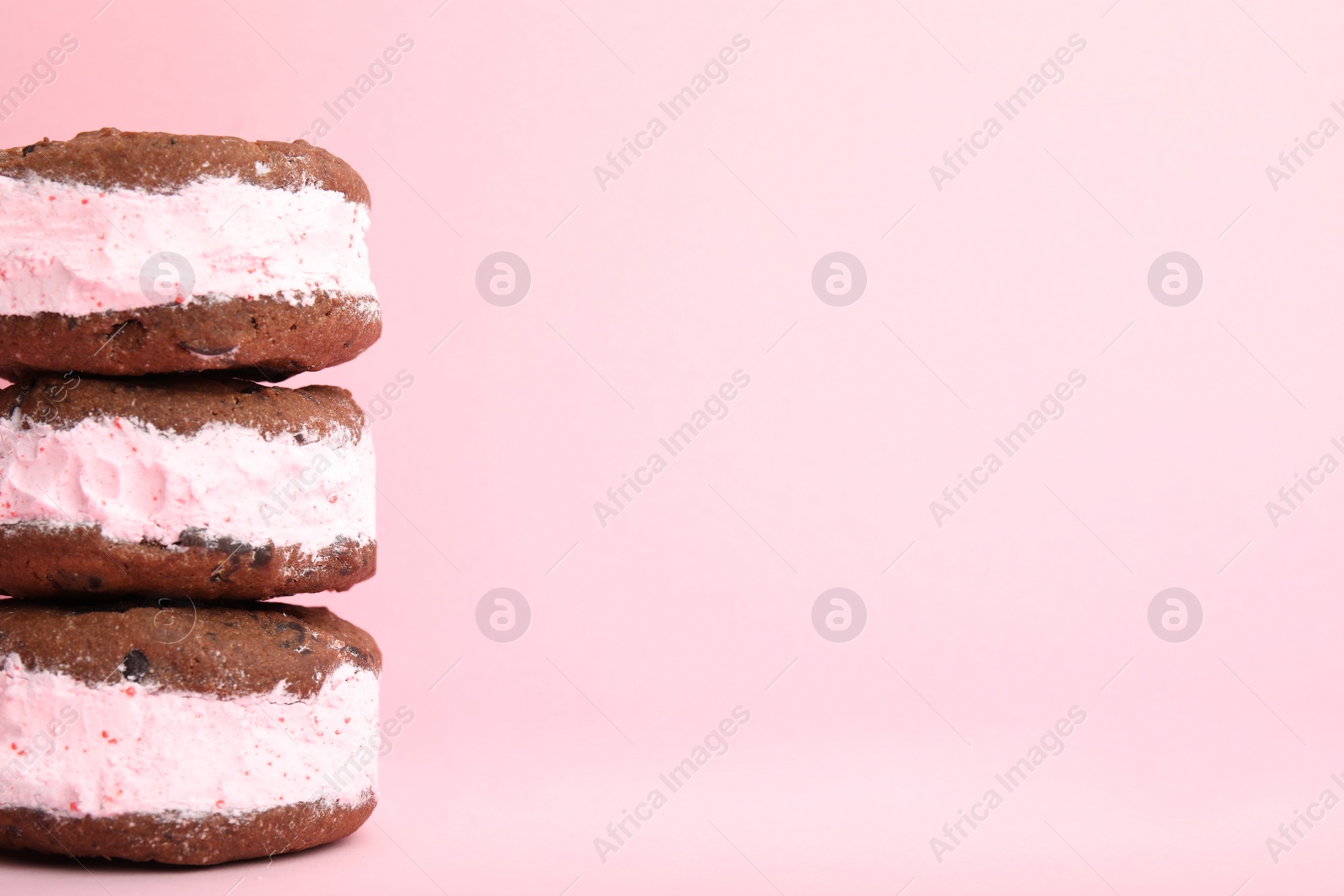 Photo of Sweet delicious ice cream cookie sandwiches on color background, space for text