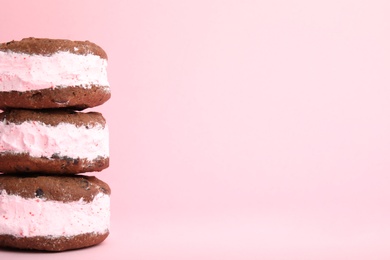 Photo of Sweet delicious ice cream cookie sandwiches on color background, space for text