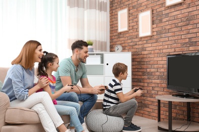 Happy family playing video games in living room