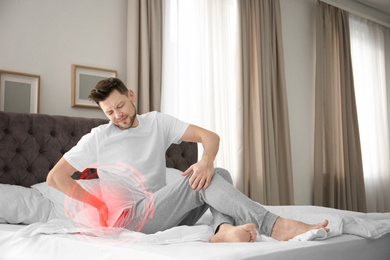 Man suffering from back pain after sleeping on uncomfortable mattress at home