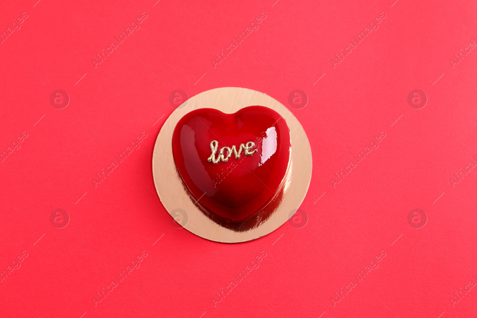 Photo of St. Valentine's Day. Delicious heart shaped cake on red background, top view