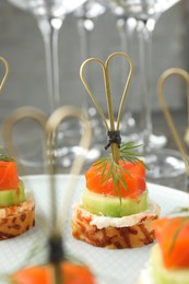 Photo of Tasty canapes with salmon, cucumber, bread and cream cheese on table, closeup