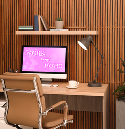 Image of Modern computer with text WORK FROM HOME on table in office