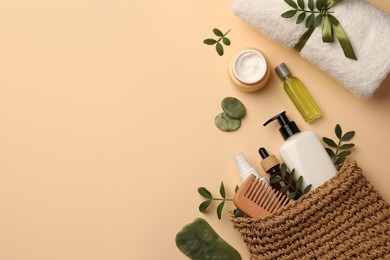 Photo of Preparation for spa. Compact toiletry bag with different cosmetic products, sea salt and towel on beige background, flat lay. Space for text
