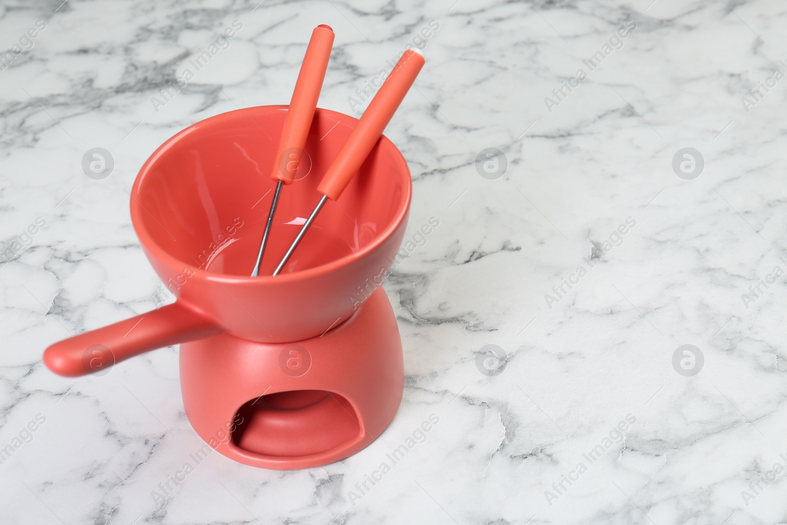 Photo of Fondue set on white marble table, space for text