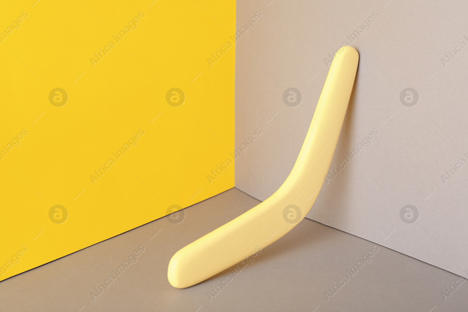 Photo of Yellow wooden boomerang on color background. Outdoor activity