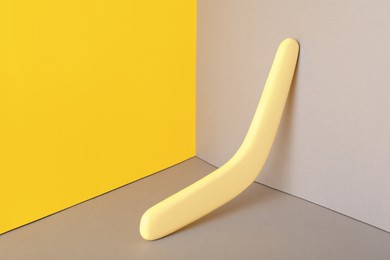 Yellow wooden boomerang on color background. Outdoor activity