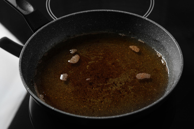 Photo of Used cooking oil in frying pan on stove
