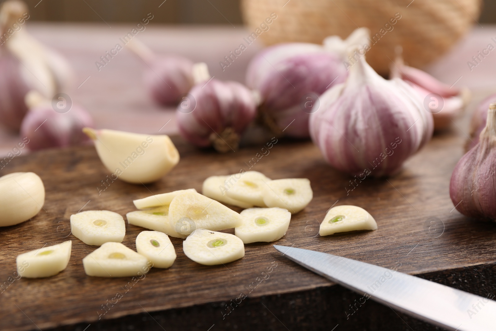 Photo of Fresh garlic and knife on table, selective focus