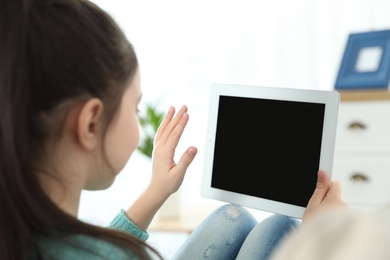 Photo of Little girl using video chat on tablet at home. Space for text
