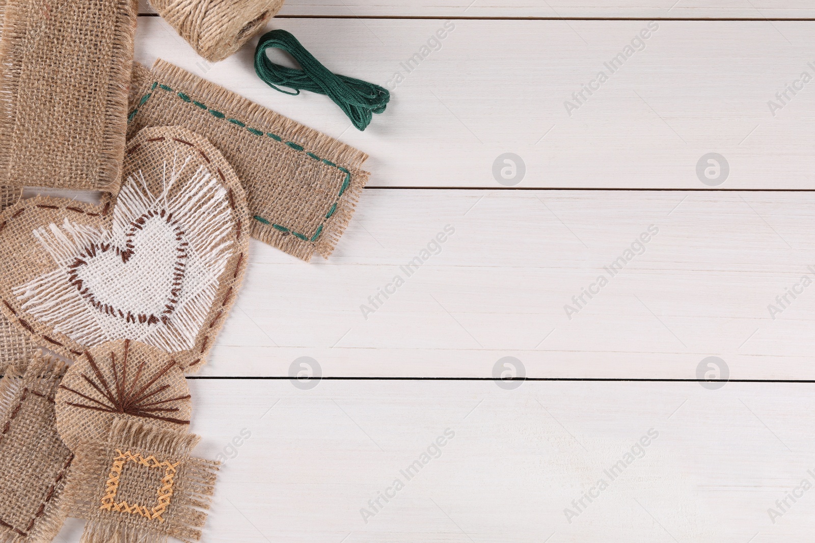 Photo of Flat lay composition with pieces of burlap fabric on white wooden table, space for text