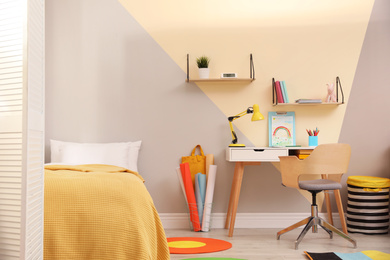 Photo of Stylish child room interior with comfortable bed and desk