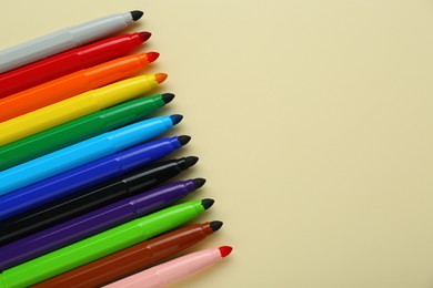 Photo of Many different colorful markers on beige background, flat lay. Space for text