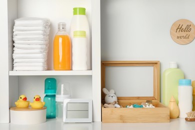 Toys and baby accessories on white rack