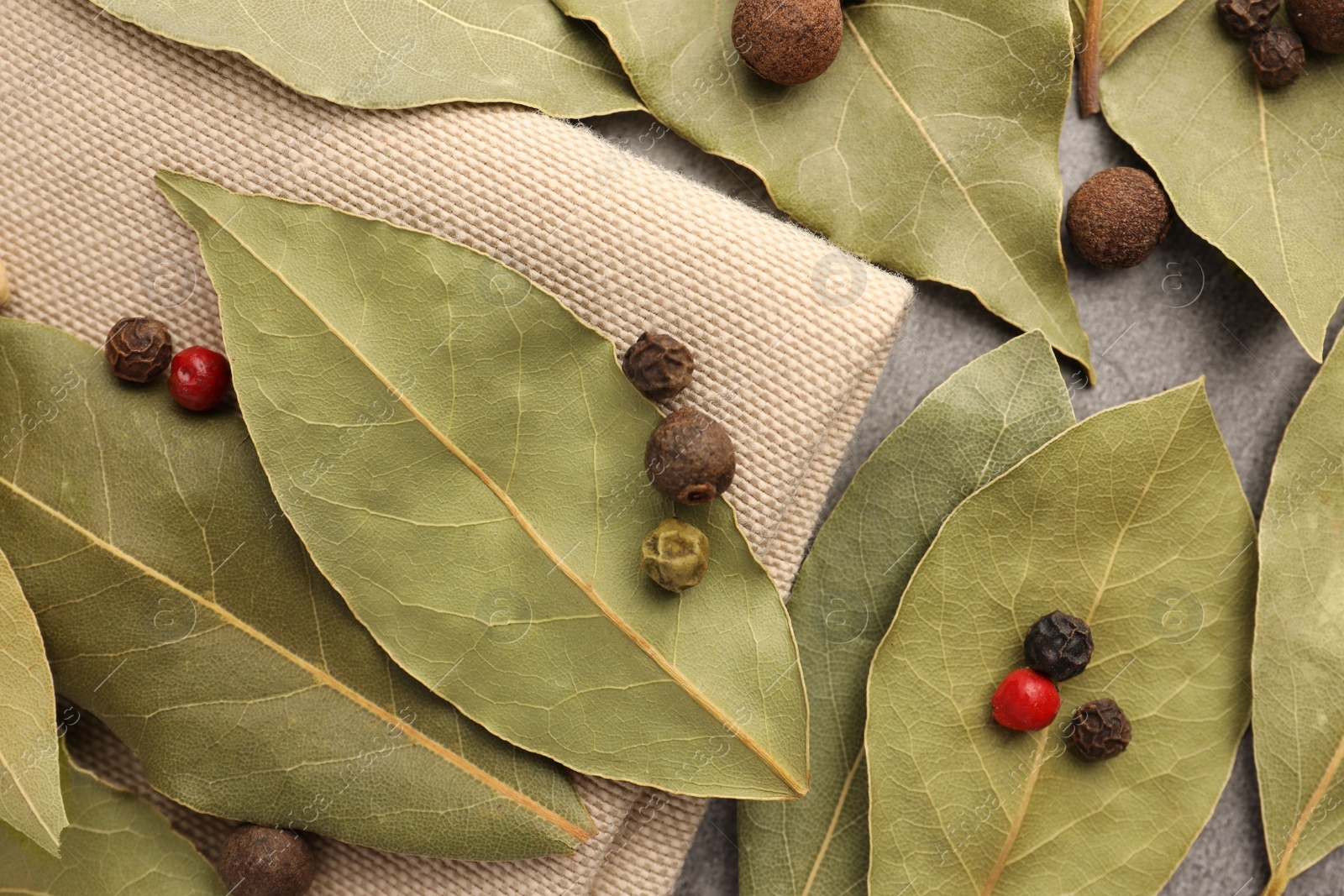 Photo of Aromatic bay leaves and spices on light gray table, flat lay