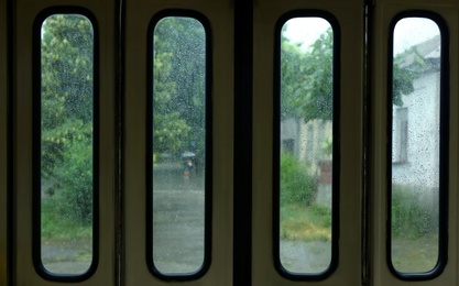 Closed wet tram doors on rainy day, view from inside