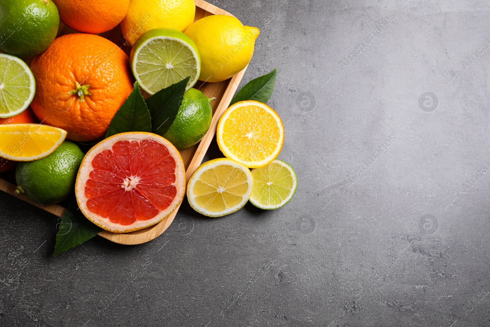 Photo of Different citrus fruits on black table, flat lay. Space for text