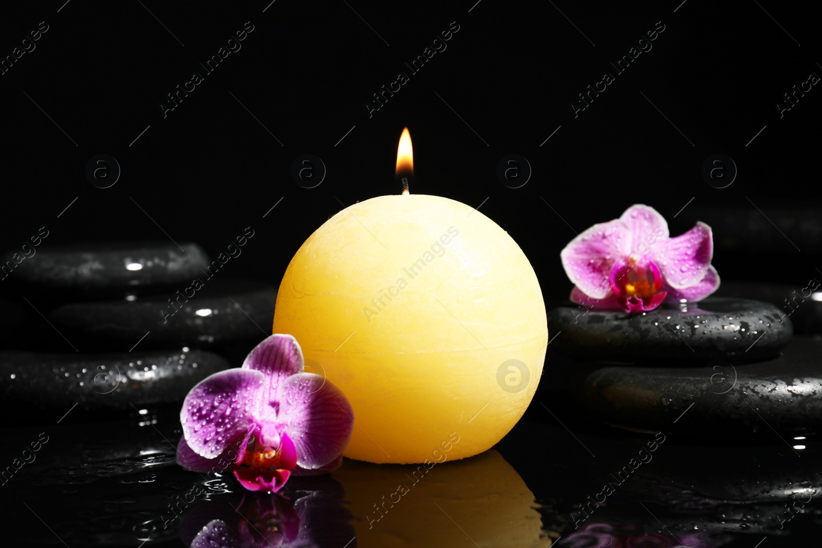 Photo of Composition with candle and spa stones on black background