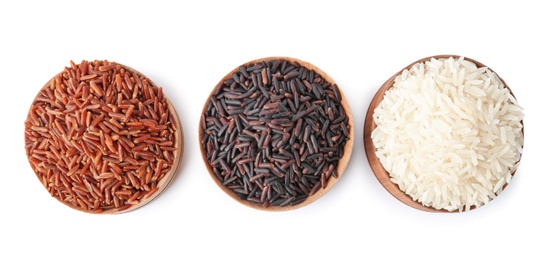 Photo of Bowls with different types of uncooked rice on white background, top view