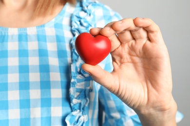 Photo of Woman holding red decorative heart, closeup view