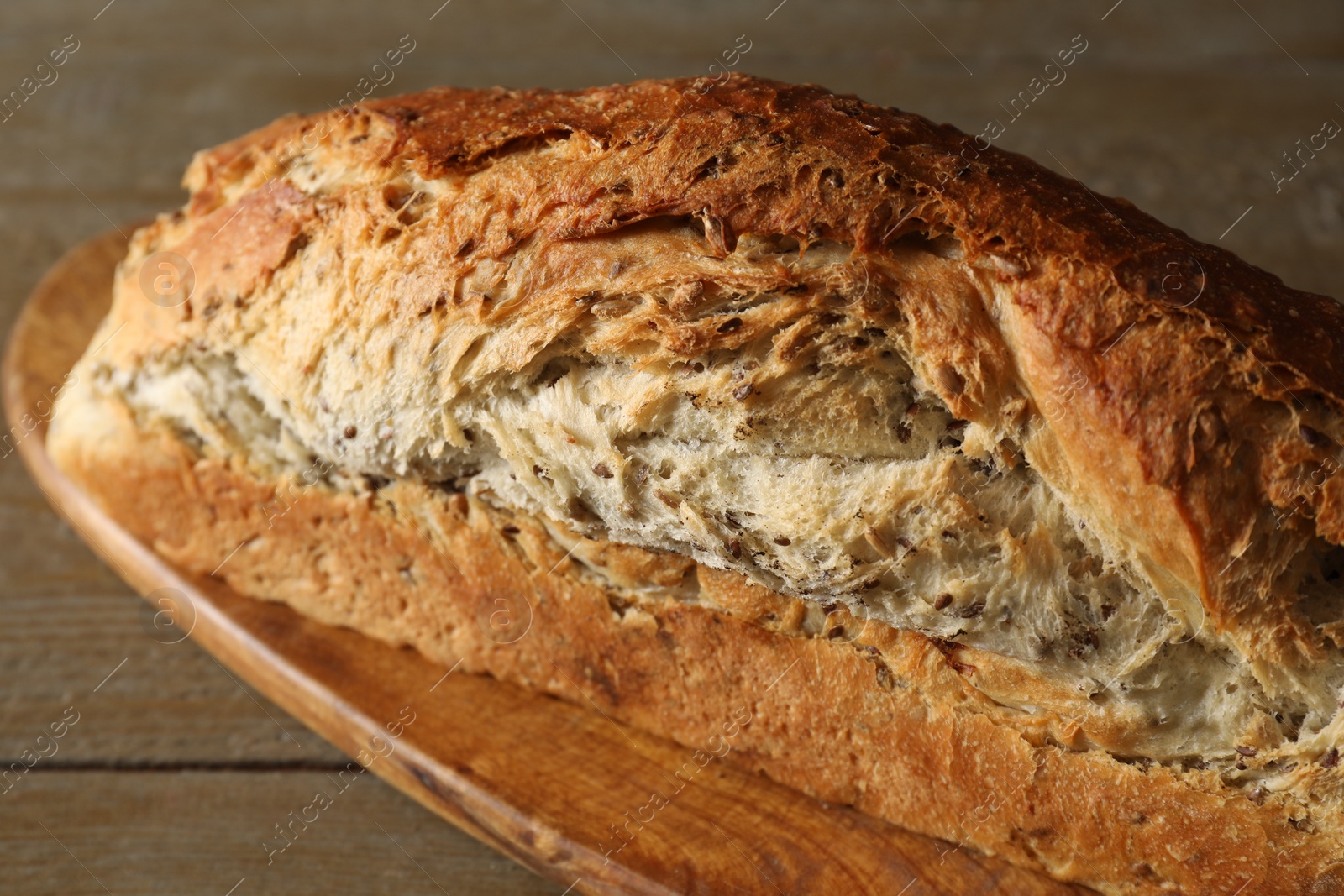 Photo of Freshly baked sourdough bread on wooden table, closeup