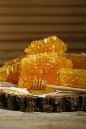 Photo of Natural honeycombs and wooden dipper on rustic table