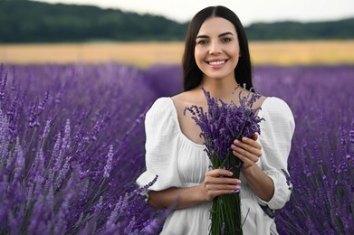 Beautiful young woman with bouquet in lavender field