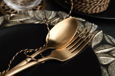 Stylish table setting with golden cutlery, closeup