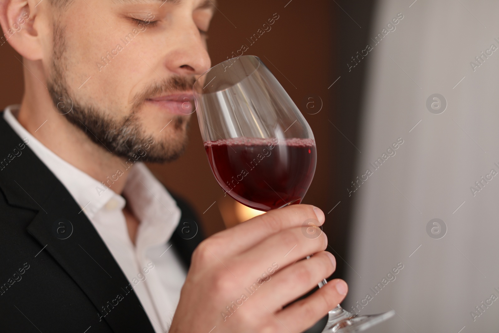 Photo of Young man with glass of wine indoors