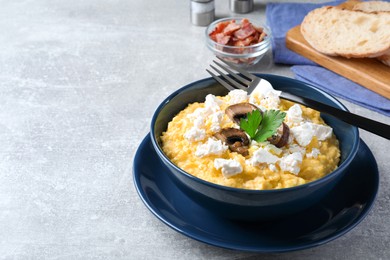 Photo of Tasty banosh served with brynza and mushrooms on grey table, space for text. Traditional Ukrainian dish