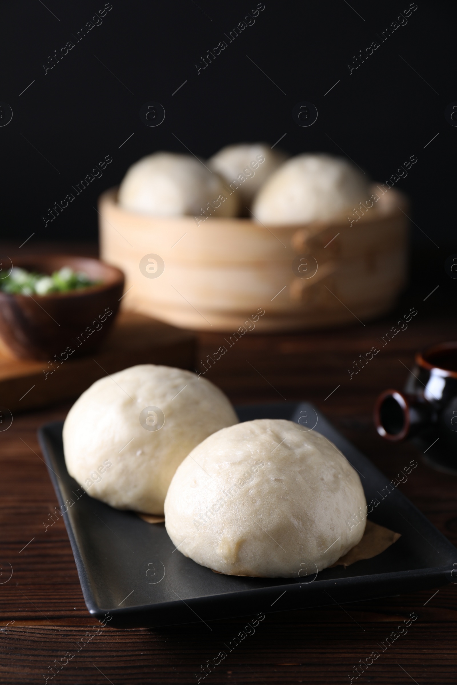 Photo of Delicious Chinese steamed buns on wooden table, closeup