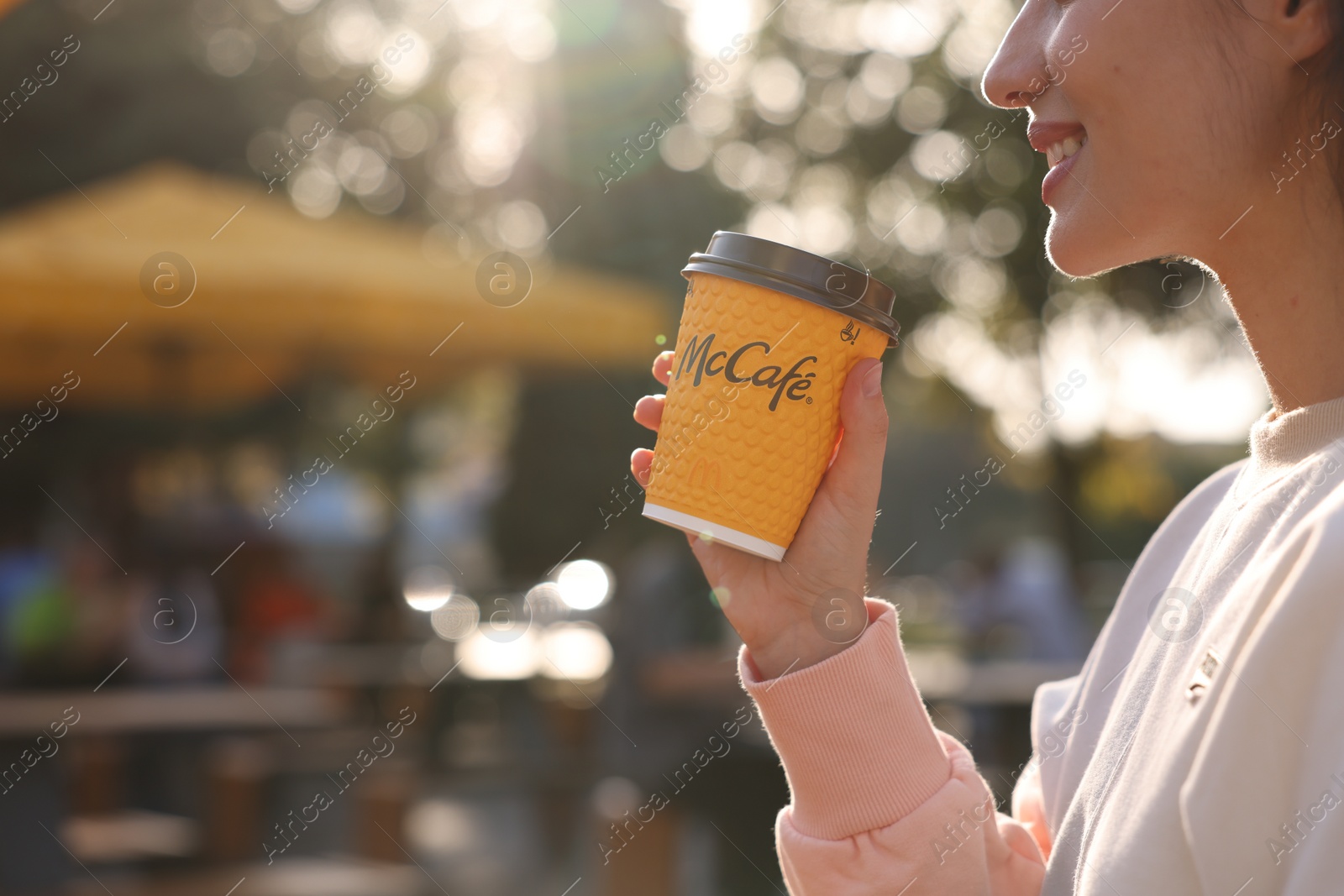 Photo of Lviv, Ukraine - September 26, 2023: Woman with hot McDonald's drink outdoors, closeup. Space for text