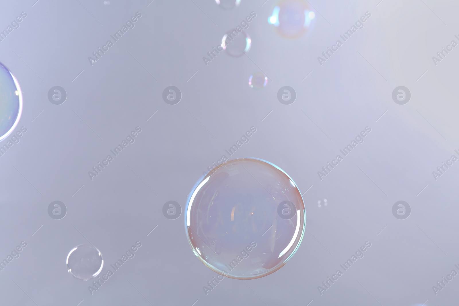 Photo of Beautiful transparent soap bubbles on gray background