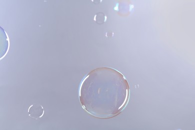 Photo of Beautiful transparent soap bubbles on gray background